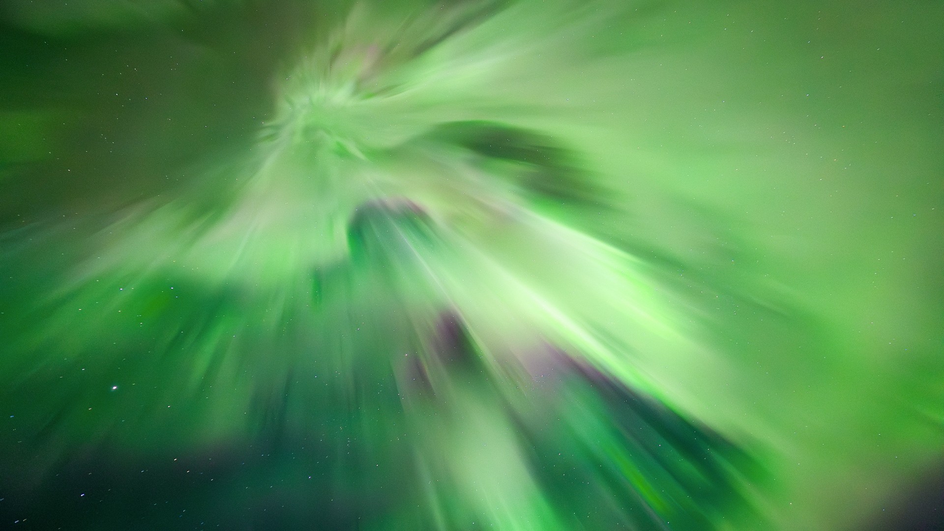 aurora overhead known as a corona whereby huge green curtains of light stretch down from the sky during an intense northern lights show.