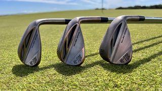 Three TaylorMade Hi-Toe 3 Wedges and their stunning copper finishes resting on the golf course