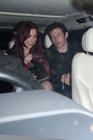 Dua Lipa and Callum Turner leaving a party together in the backseat of a car