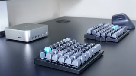 The Keychron Q11 Ultra split mechanical keyboard next to a vertical mouse and a mini PC on a desk
