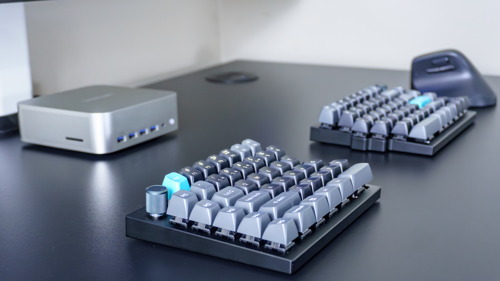 The Keychron Q11 Ultra split mechanical keyboard next to a vertical mouse and a mini PC on a desk