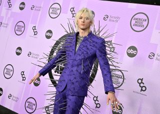 Machine Gun Kelly at 2022 AMA Awards, celebrity fashion moment in purple suit.