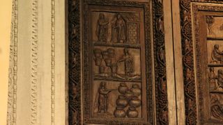 A wooden door at the Santa Sabina Church in Rome shows Jesus with a “wand" performing miracles: (top to bottom) Jesus raising Lazarus; Jesus multiplying loaves and fish; Jesus turning water into wine. 