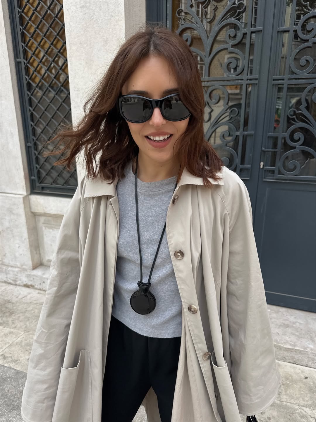 Woman in a trench, tee, and long necklace