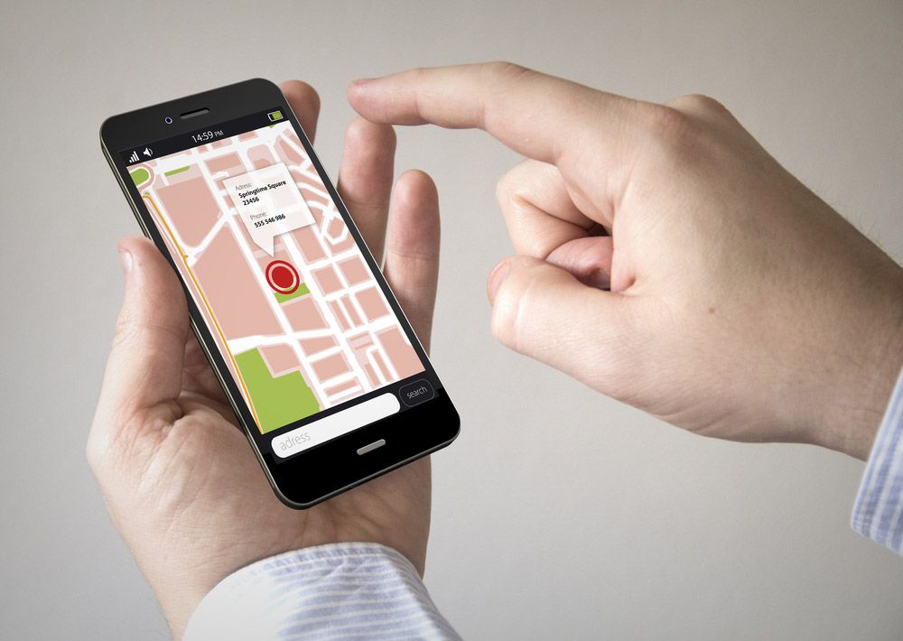 Hand checking location data on a smartphone.