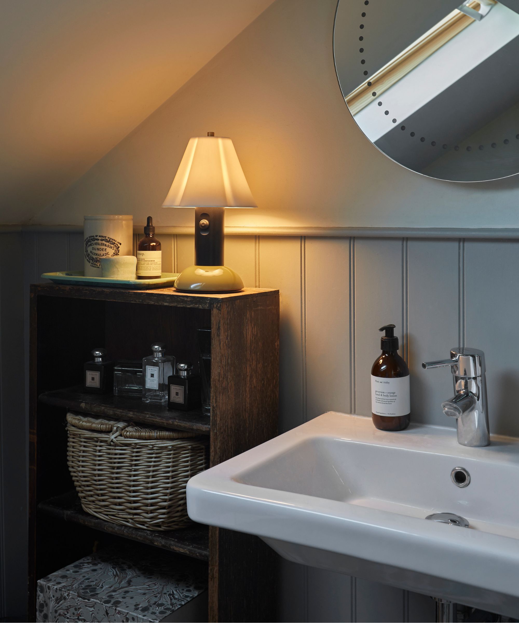 modern bathroom with antique storage and a lamp