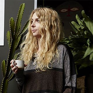 designer abigail ahern with potted plants and grey wall