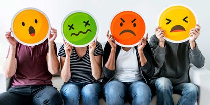 Four people holding up frustrated emoji faces.