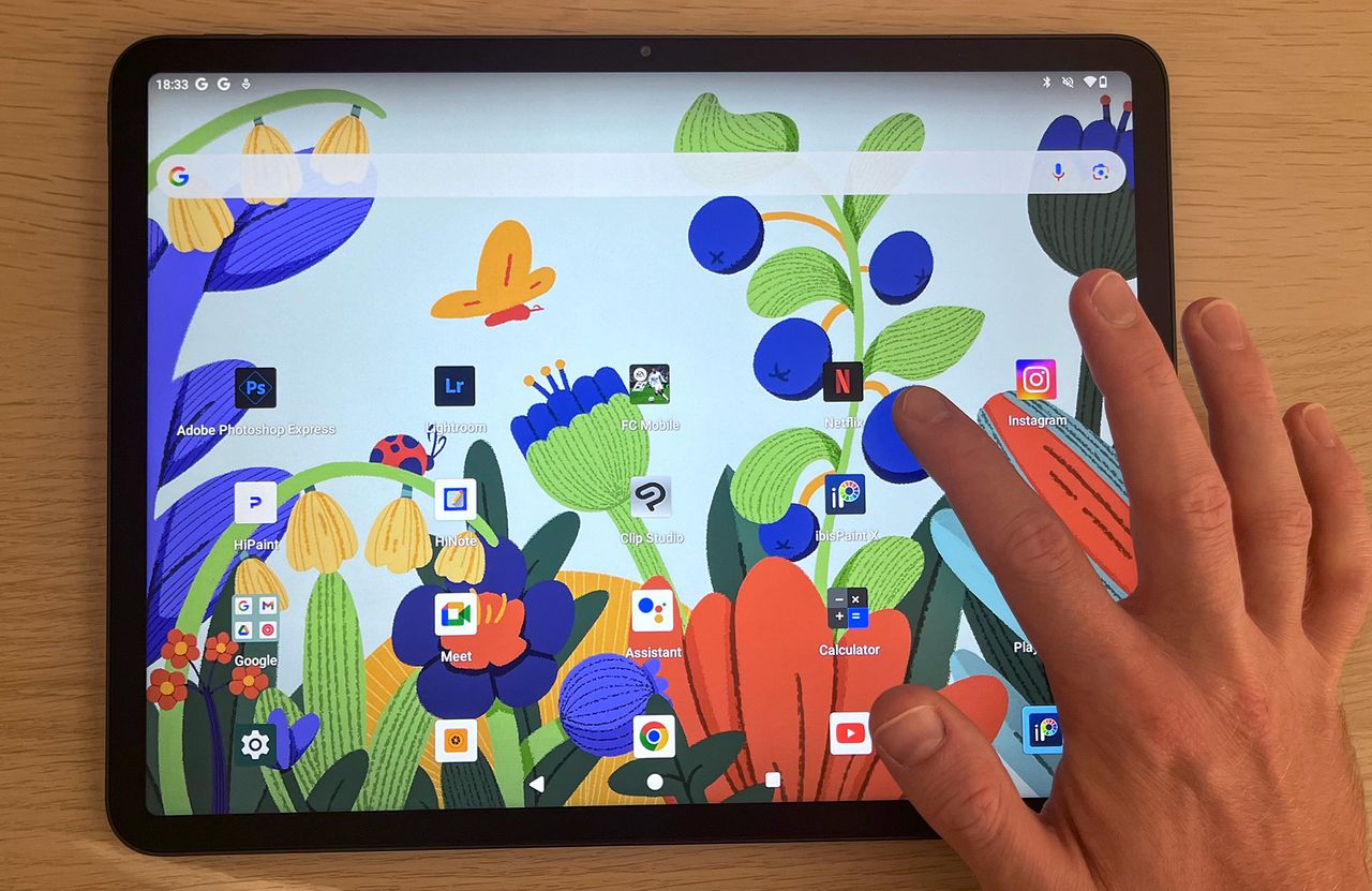Hand tapping screen of Huion Kamvas Slate 13 main screen with apps visible