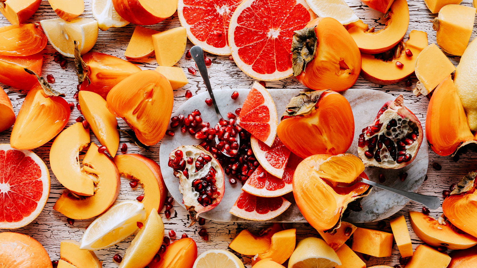 mixed fruits chopped, sliced and crushed on white wooden table