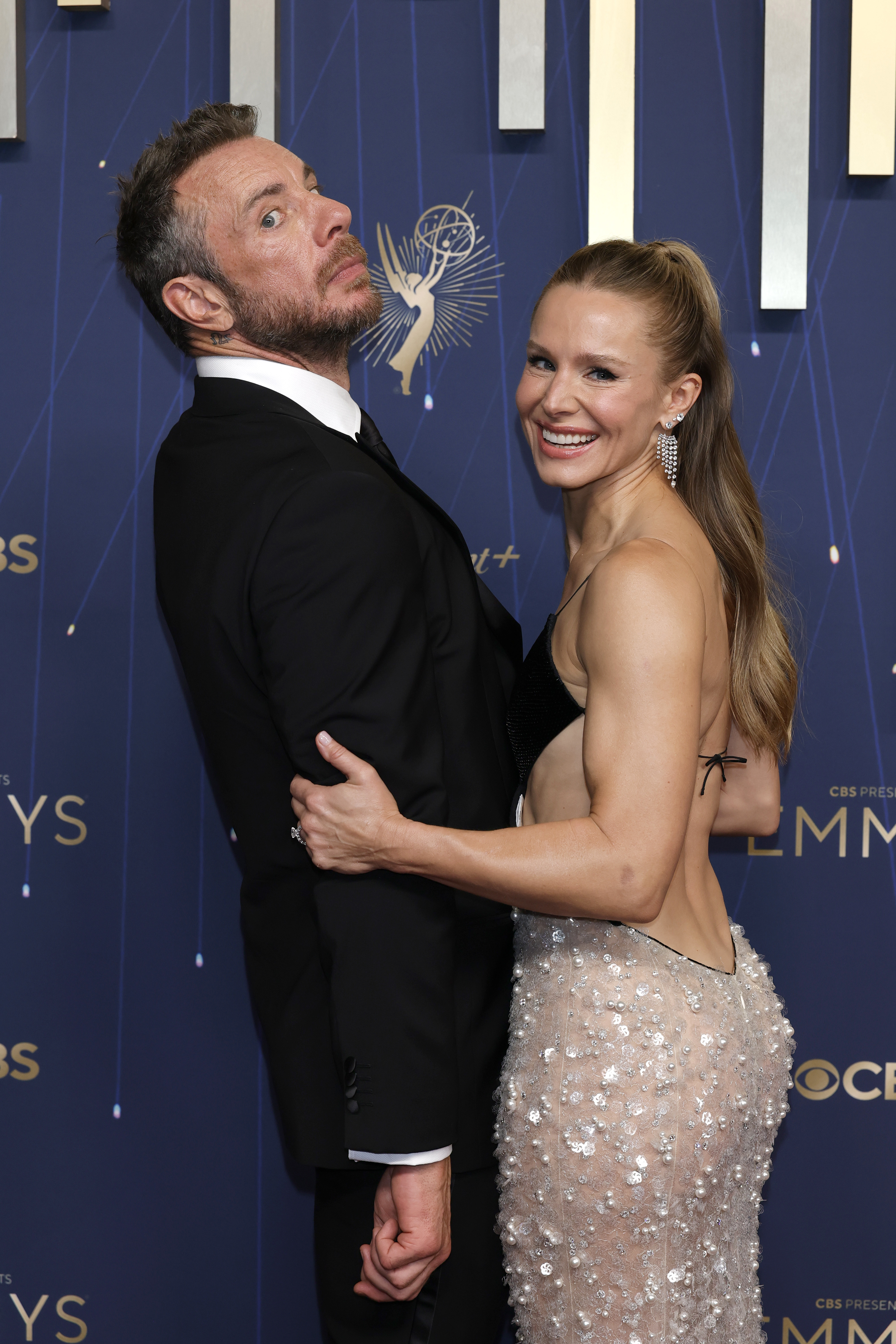 a man and a woman in front of a blue wall