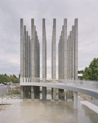 External view of concrete pavilion and a bridge to reach it