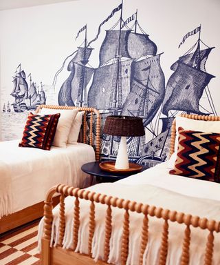 bedroom with tall ship mural and twin beds with turned wood details