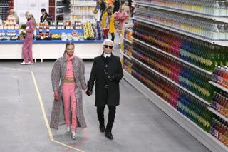 German fashion designer Karl Lagerfeld, flanked by British model Cara Delevingne, acknowledges the audience at the end of Chanel 2014/2015 Autumn/Winter ready-to-wear collection fashion show