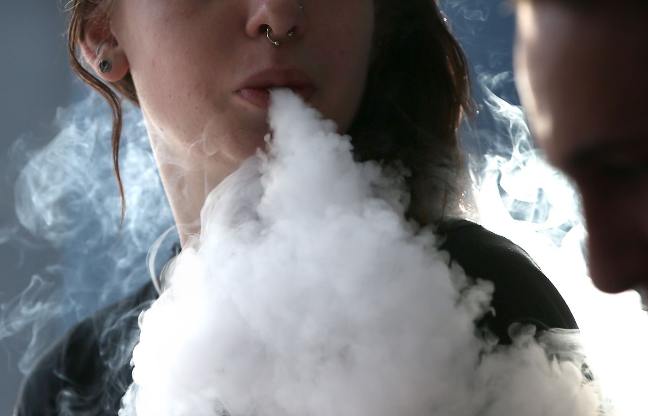 A woman smokes an e-cigarette