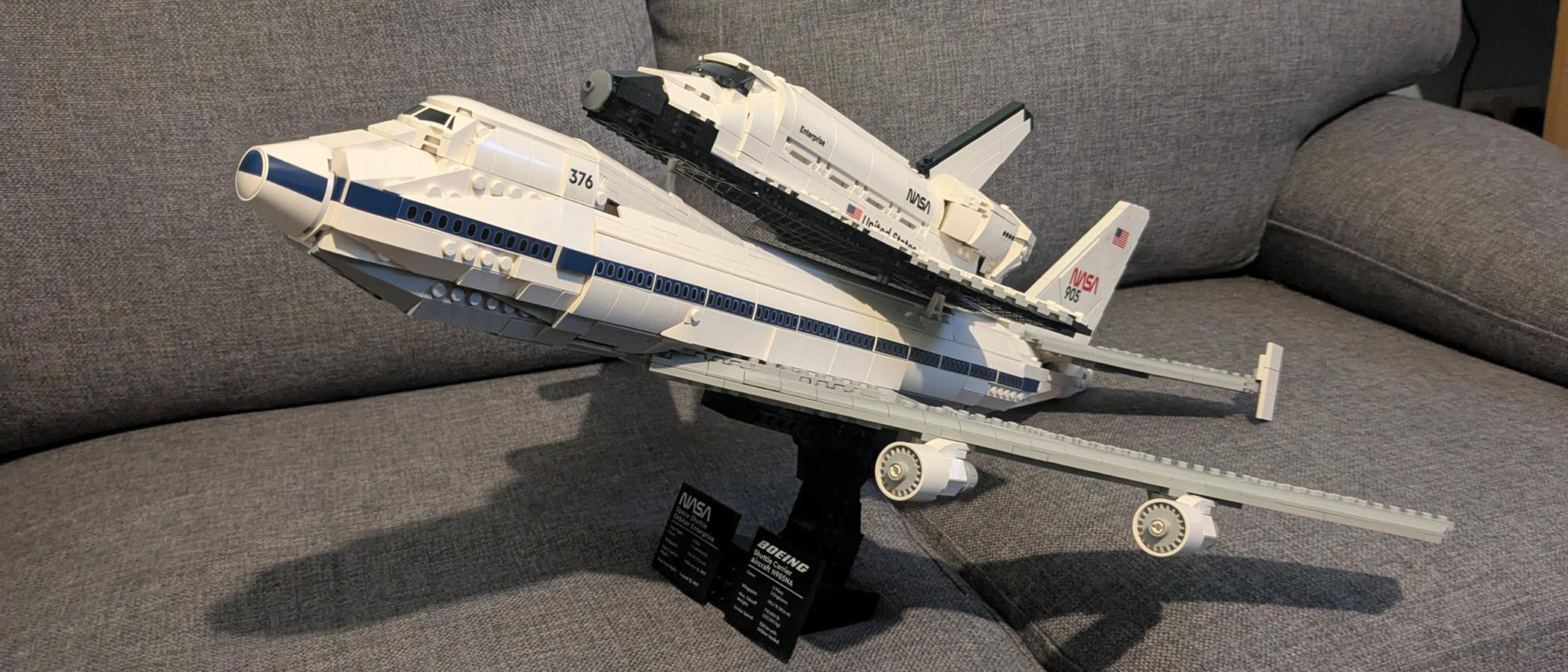 A Lego Icons Shuttle Aircraft Carrier on its stand, the shuttle on the back of the plane. 