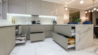 Open drawers at modern white kitchen furniture