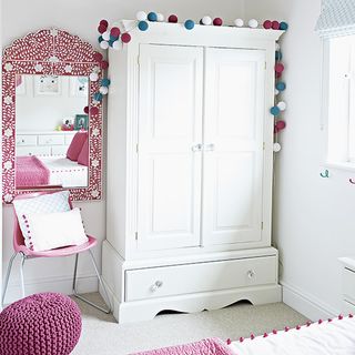 childs room with white wardrobe and mirror and white wall and chair