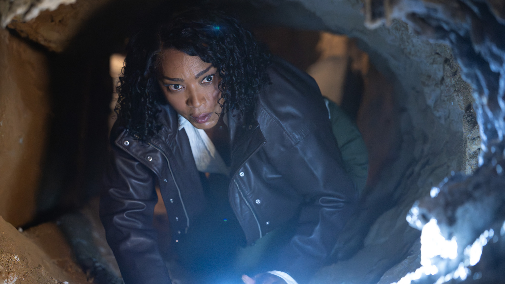 Athena (Angela Bassett) looks curious as she navigates the inside of a crawlspace on 9-1-1.