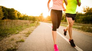 A man and woman running on a road