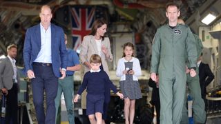 Prince William, Prince of Wales and Catherine, Princess of Wales with Prince George of Wales, Princess Charlotte of Wales and Prince Louis of Wales (C) as they walk down the ramp of a C17 plane during their visit to the Air Tattoo at RAF Fairford