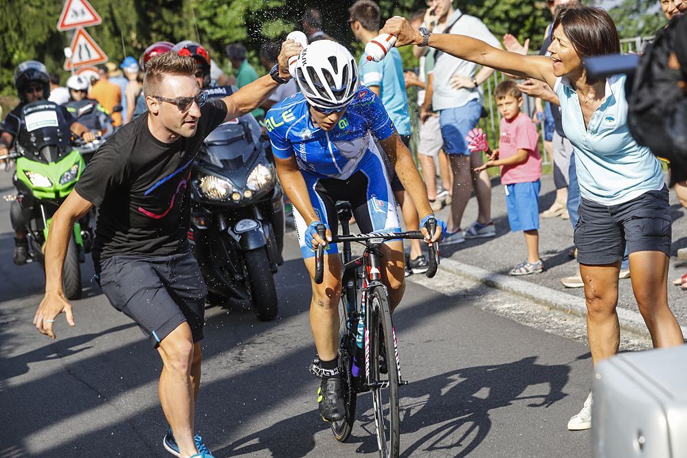 Elena Cecchini gets a feed from Elia Viviani in the feed zone