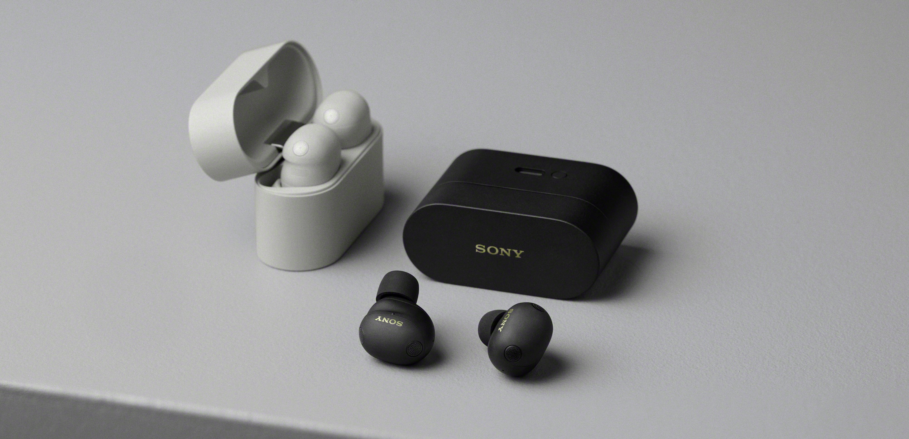 Sony WF-1000XM6 wireless earbuds in black and platinum silver on a grey surface