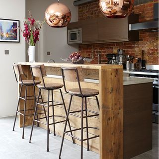 wooden island with copper pendant lights