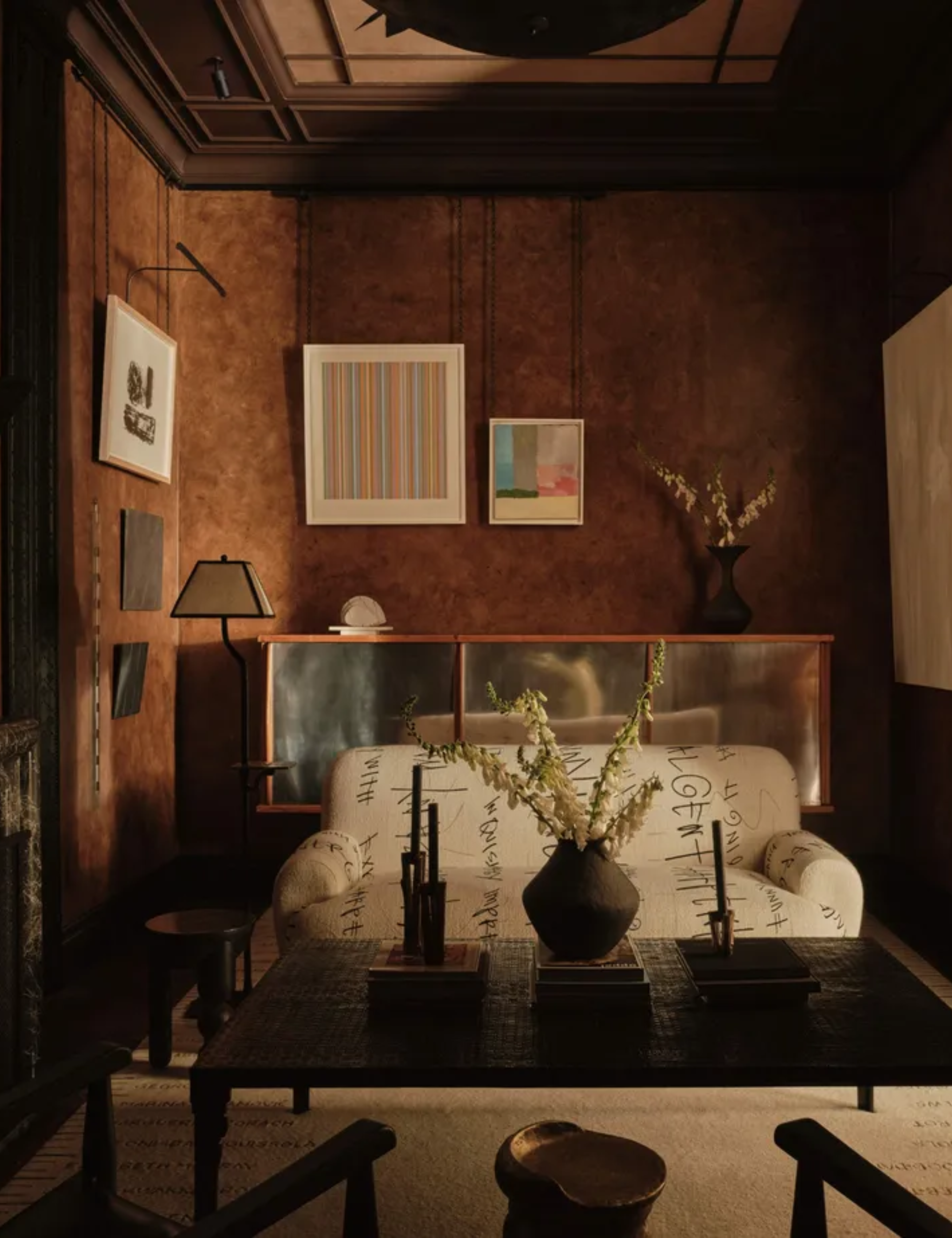 Moody living room with textured brown walls and a mix of old and new furniture
