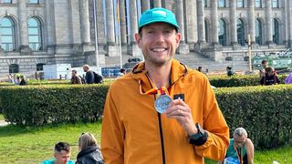 Nick Harris-Fry holding a Berlin Marathon finisher’s medal