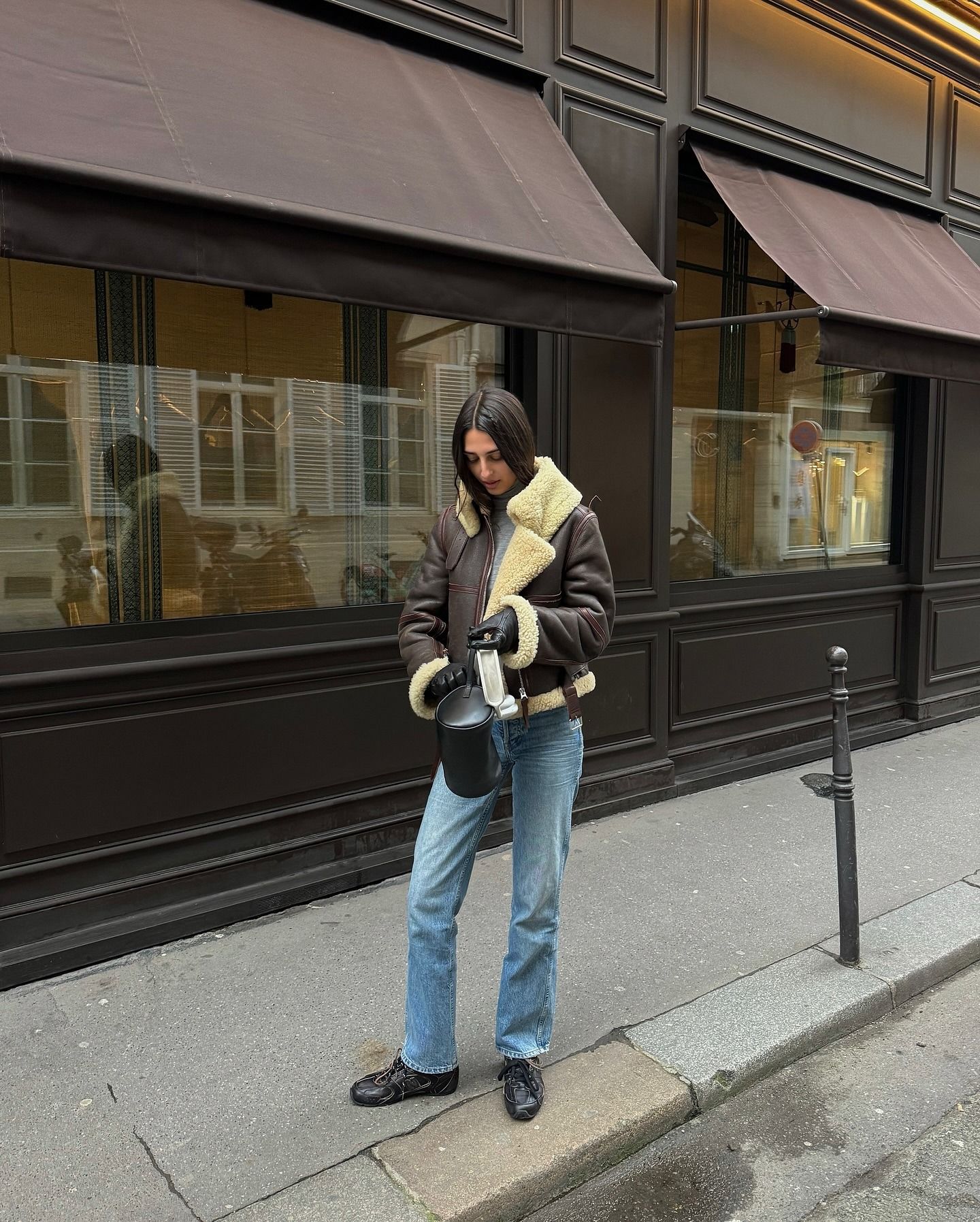 Influencer @salome.mory wears a sheepskin leather jacket with cigarette jeans a low-profile trainers.