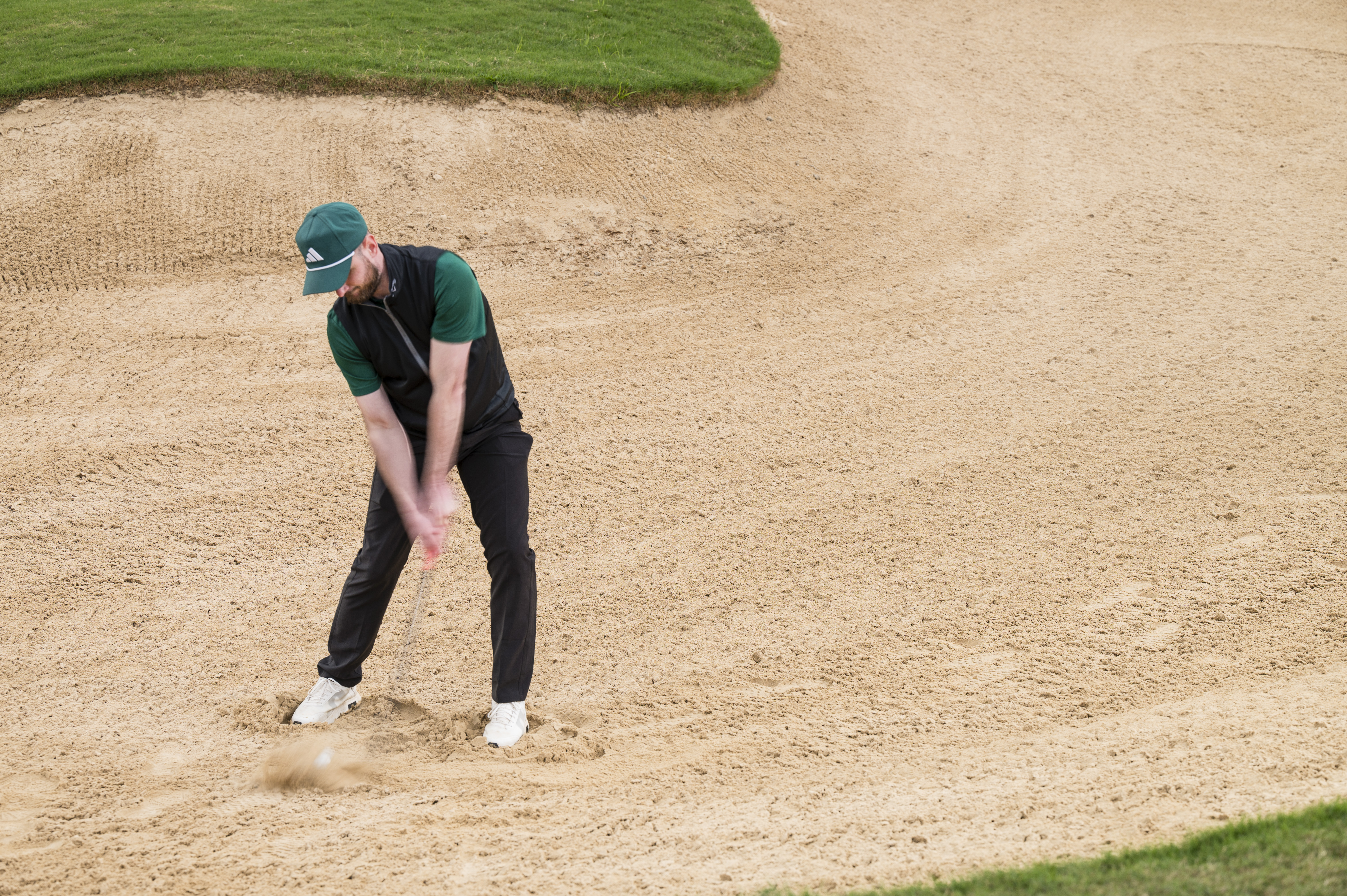 Baz Plummer hitting a bunker shot