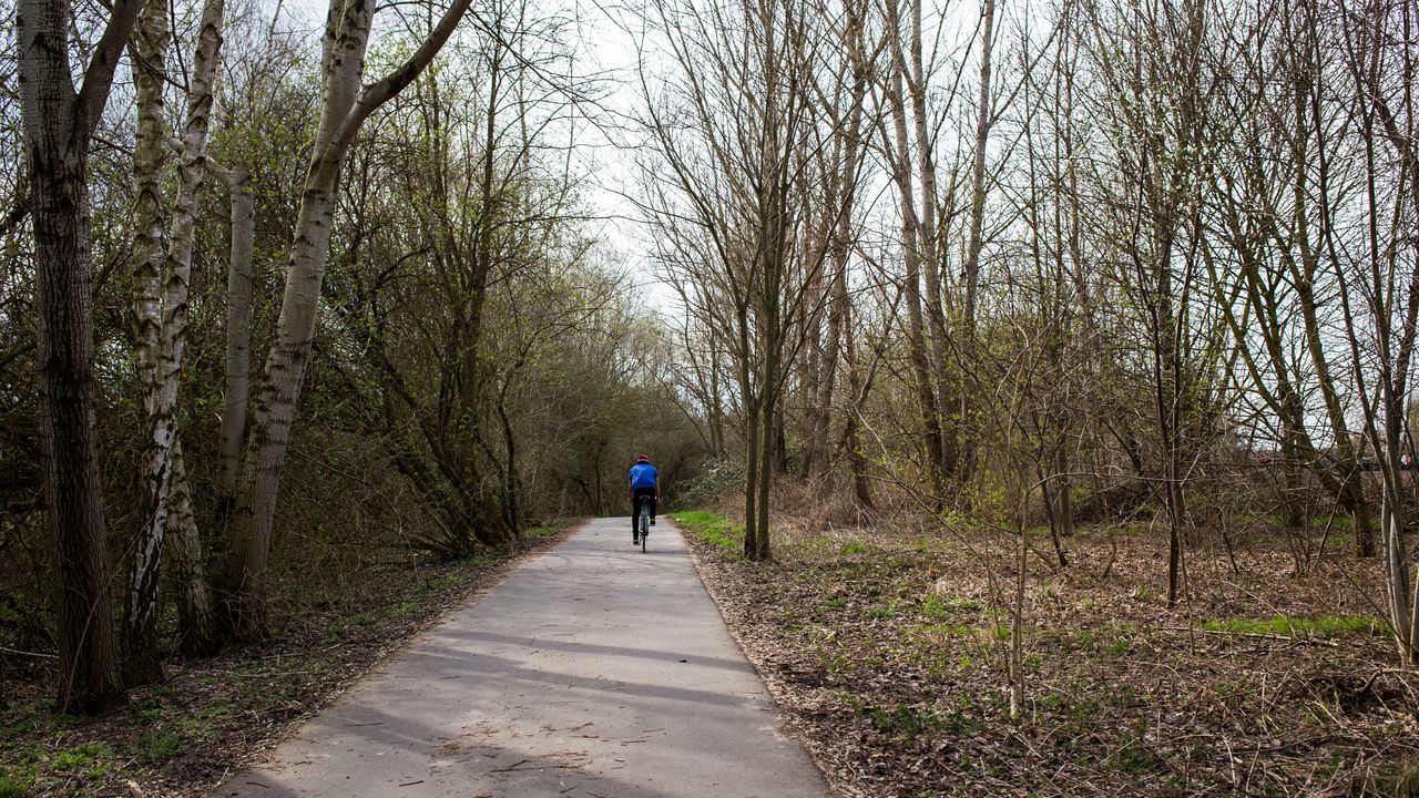 A cyclist rides along the Berlin Wall trail