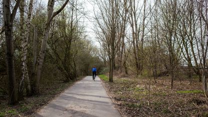 A cyclist rides along the Berlin Wall trail