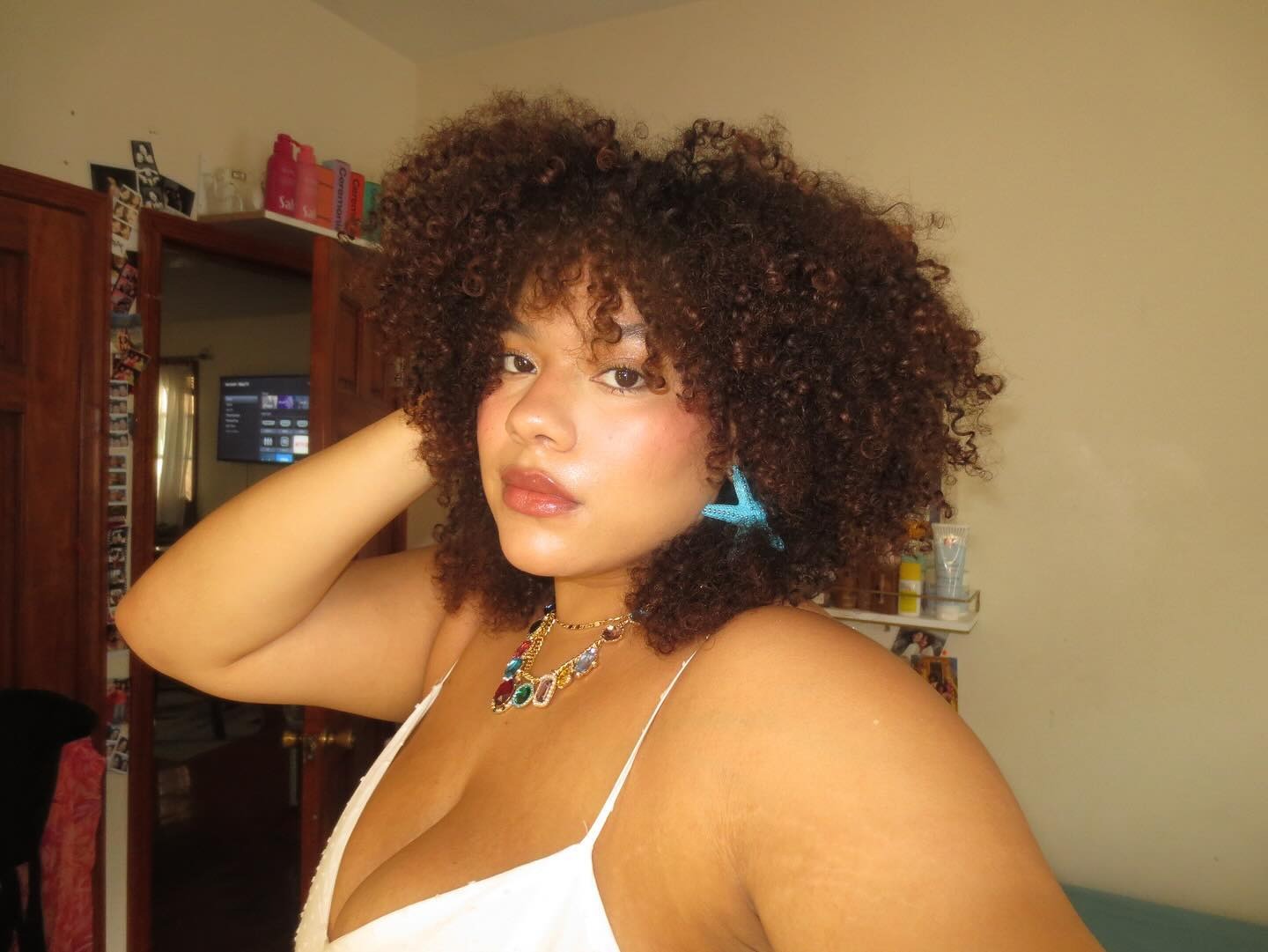 A woman taking a selfie with a curly, shag hairstyle