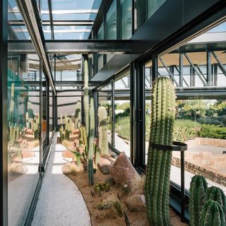 Green-tinted photovoltaic windows surround the structure responding to its proximity to the highway