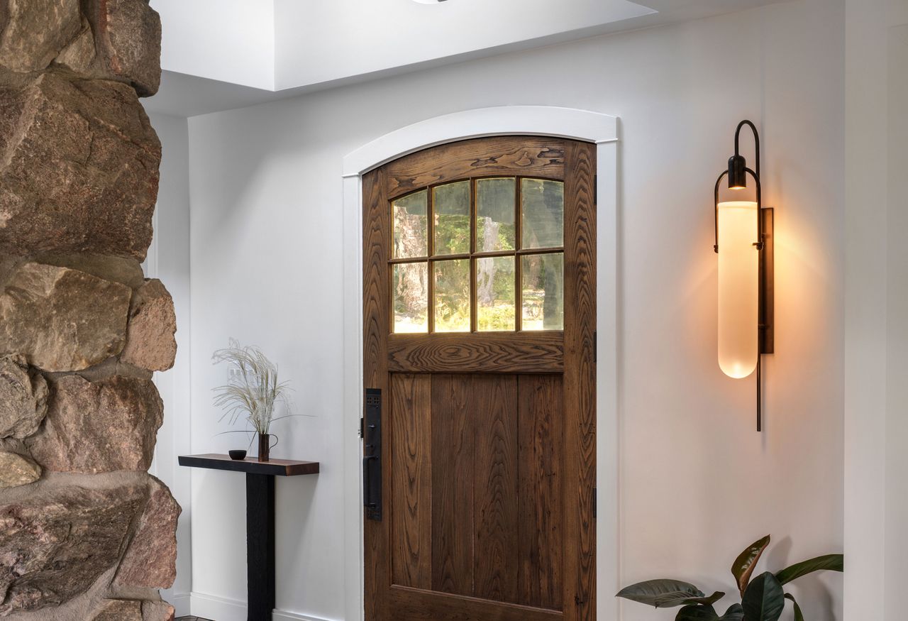 an entryway with a skylight and wall lamp