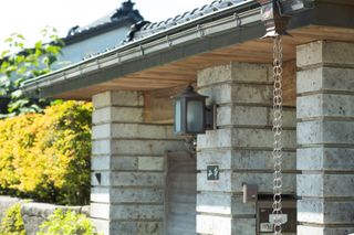 Japanese style rain chain hanging from a roof