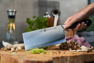 A Zwilling Pro Chinese Chef Knife on a chopping board