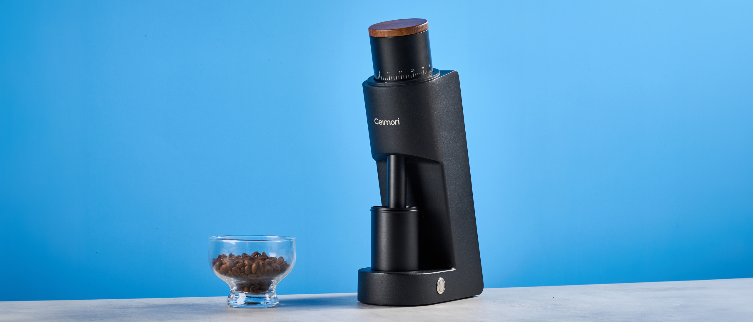 the wirsh geimori gu38 coffee grinder in black with a walnut hopper lid photographed against the blue tom's guide background