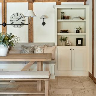 A light neutral-coloured dining room with a long rectangular table, a dining bench and banquette seating