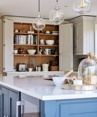 Cream kitchen cupboard storage ideas with bi-folding pocket doors.