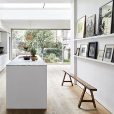 White modern kitchen with a glass rooflight and a white kitchen island unit