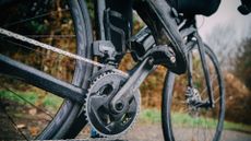 Male cyclist riding in the rain using some of the best clipless pedals