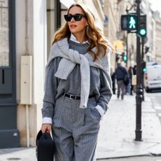 a woman wears a gray sweater in Paris