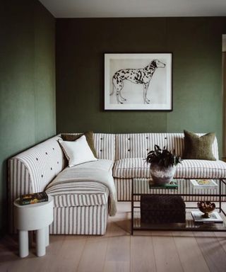 moody living room with striped armless sofa and a large sketch of a dog