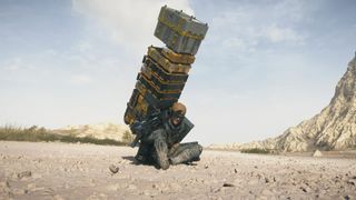 Death Stranding 2 carry capacity: Sam sitting down in the desert with a large tower of boxes on his back.