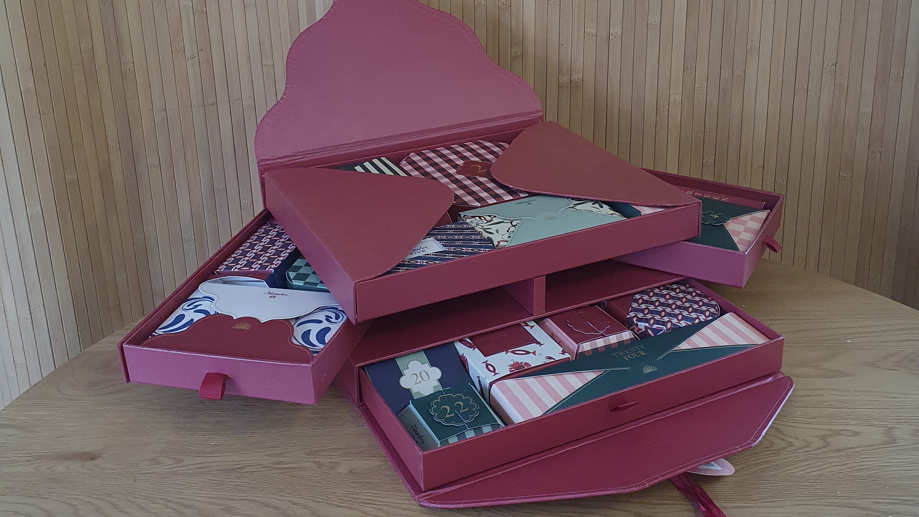 Papier's stationery advent calendar 2025 open on a round table with a panelled backdrop