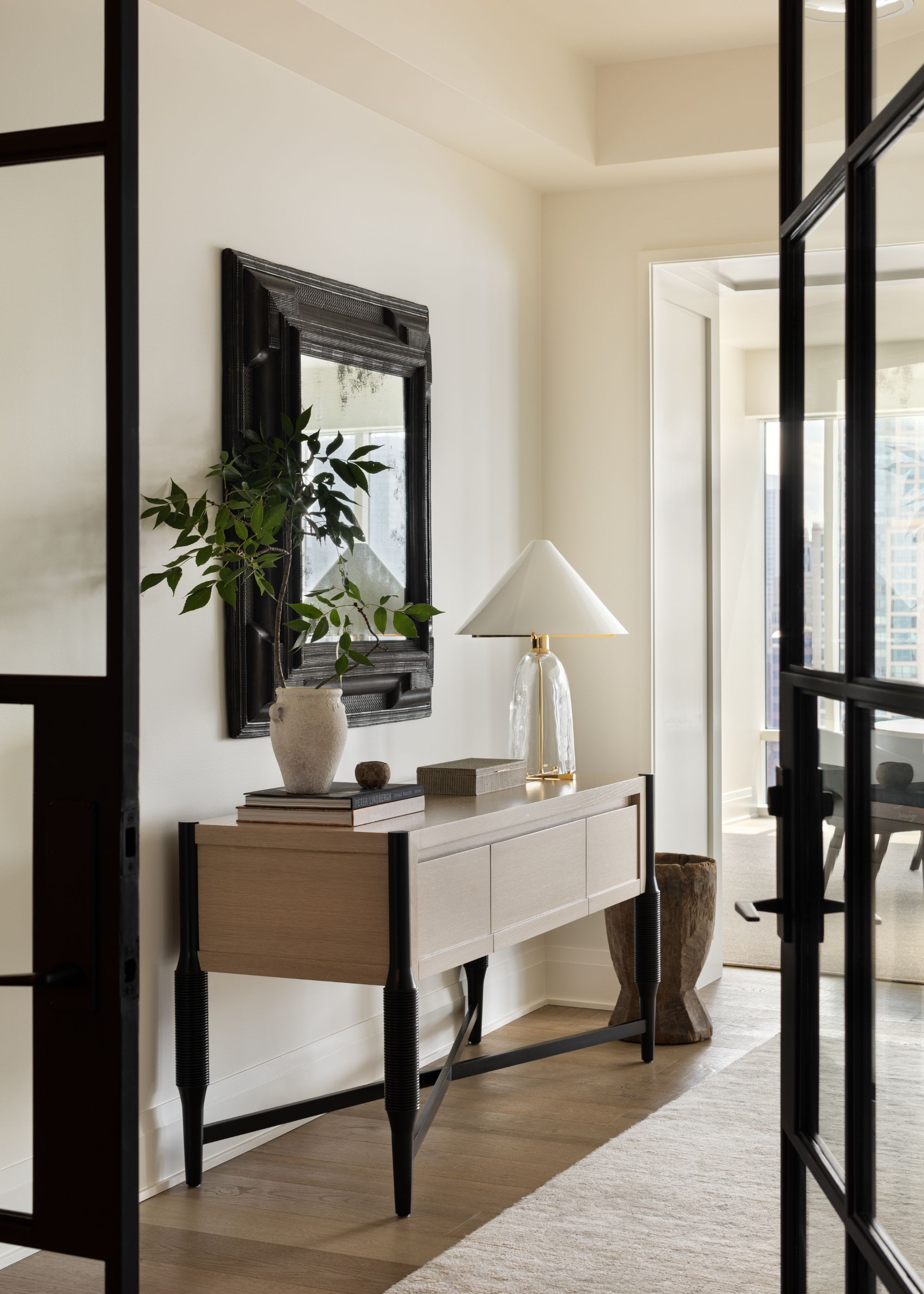 modern neutral entryway with console table with lamp, books and foliage