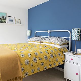 Main bedroom with blue wall and bed